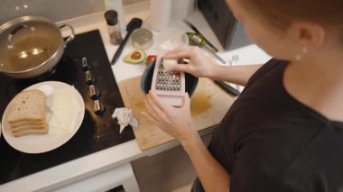Modern Kitchen 'da, Siyah Tişörtlü Kadın Kasenin Üzerindeki Kaynamış Yumurta Peynir ve Ekmek Yanındaydı.