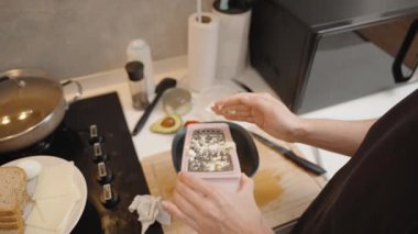 Modern Mutfak 'ta Siyah Tişörtlü Kadın Plastik Kâse Üzerine Kaynamış Yumurta Pişiriyor.