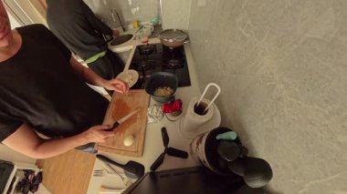 Modern Kitchen 'da Siyah Tişörtlü Kadın Ahşap Kesme Tahtasında Kaynamış Yumurta Kesiyor, Geniş Açı Bakış Açısı