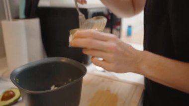 Siyah Tişörtlü Kadın Modern Mutfakta Izgara Yumurtayla Bovlinge Konserve Ton Balığı Ekliyor