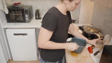 Siyah Tişörtlü Kadın, Modern Mutfak 'ta Ton Balığı ve Izgara Yumurtayla Siyah Biber Öğütüyor.