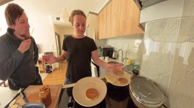 Erkek ve Kadın Modern Mutfakta Fıstık Ezmeli Krepleri Hazırlarken Geniş Açı Görünümü Tadına Bakıyor