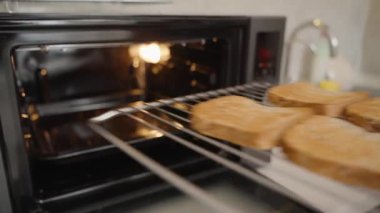 Fırın Eldiveni Giyen Kişi Sıcak Tost Fırını 'ndan Kızarmış Ekmek Dilimlerini Kaldırıyor
