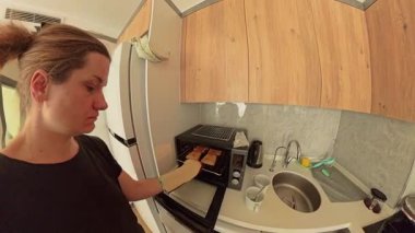 Fırın Eldiveni Giyen Kadın Modern Kitchen 'daki Ekmek Kızartma Fırını' ndan Ekmek Kaldırıyor