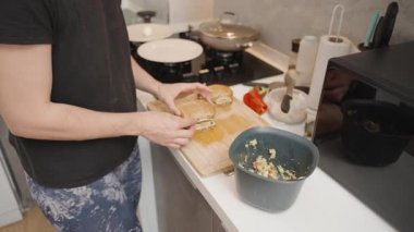 Sandviç ve haşlanmış yumurtayı Modern Mutfak 'taki ocağın yanına yerleştiren kişi.