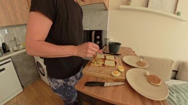 Cozy Kitchen 'da peynirli tost üzerine ton balığı serpiştiren kadın manzarası