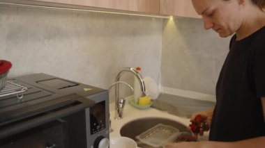 Modern bir mutfakta Akan Su Altında Taze Çilek Yıkan Kişi