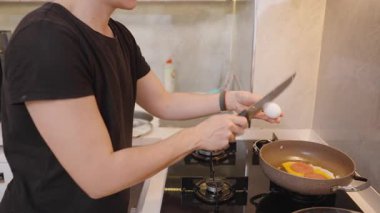 Modern Mutfak 'ta Kahvaltı Pişirirken Kızarmış Yumurta ve Sosis Üzerine Yakın plan İnsan Fışkırtması. Pişirme Süreci Konsepti