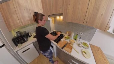 Geniş Açı Kadın Ocağında Manzara Modern Mutfak 'ta Ahşap Dolaplar ve Tezgahta Çeşitli Malzemeler Var. Ev Yemekleri Konsepti