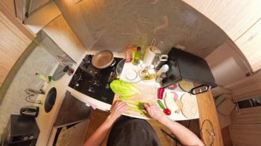 Taze sebzeler, Ekmek ve Mutfak Malzemeleri ile çevrili, Küçük bir Mutfakta Bir Kadın Kesme Marulunun 360 derecelik birinci şahıs görüntüsü