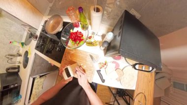 Modern Mutfak 'ta Taze Malzemeler ve Yemek Malzemeleri ile çevrili, Küçük Öğütücüde Izgara Sarımsağın 360 derecelik birinci şahıs görüntüsü