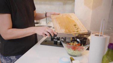 Ellerin Dilimlenmiş Yeşil Zeytinleri Tahta Kesme Tahtasından Modern Mutfakta Taze Salata İçindekiler ile Cam Kaseye Taşıması