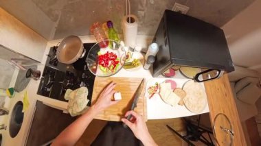 Tahta kesme tahtasındaki Brynza Peynirini 360 derecelik birinci şahıs görüntüsü. Küçük bir mutfakta taze malzemeler ve mutfak gereçleri ile çevrili.