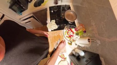 Tahta kesme tahtasındaki patatesi soyan bir insanın 360 derecelik birinci şahıs görüntüsü. Küçük bir mutfakta taze malzemeler ve mutfak gereçleri ile çevrili.