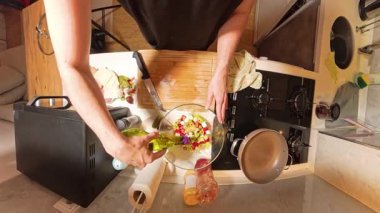 Mutfaktaki bir gaz ocağında sıcak bir tavaya zeytinyağı döken ilk kişi görüntüsü