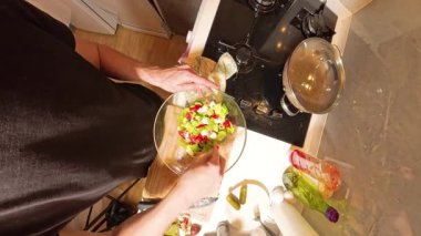 Mutfak tezgahında Doğranmış Sebzelerle Cam Kasede Taze Salata Karıştıran Kadın Görünümü Malzemeleri ve Yemek Malzemeleri Yakınında