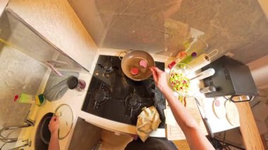 Küçük Mutfak 'ta Sosis Pişirme ve Çeşitli Malzemelerle İlk Kişi Görünümü' nden Gaz Fırınında Kızartma Tavası 'na yumurta çatırdatan kişi. Pişirme Süreci Konsepti