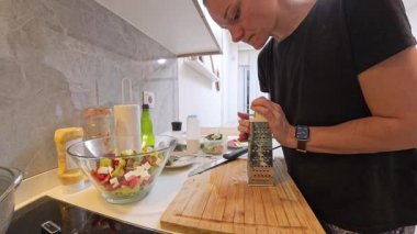 Büyük Cam Salata Kasesi ve Mutfak Malzemeleri ile Tahta Kesme Kurulu 'nda Siyah Gömlekli Kadın Izgara Peynir. Yemek Hazırlama Konsepti