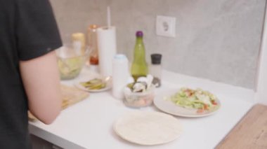 Modern Kitchen 'da sosisli fırında mermer kaplama ile tavada yumurta pişiren kişi. Kahvaltı Hazırlama Konsepti