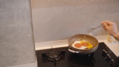 Modern Mutfakta Kahvaltı Pişirirken Kişi Kraker Kraker Yumurtası 'nı Fırında Kızartma Tavası' na sokun. Pişirme Süreci Konsepti