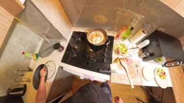 Küçük Mutfak 'ta yemek pişirirken tavaya ketçap döken kişinin tepeden görünüşü. Yemek Hazırlama Konsepti