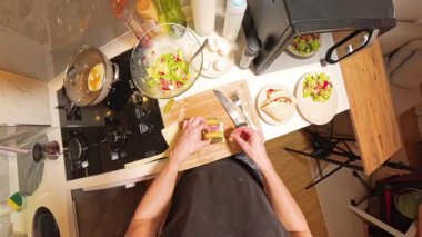 Küçük Mutfak 'taki Tahta Kesme Kuruluna Ketçap döken Kişi Genel Görünümü ve Yakınındaki Çeşitli Malzemeler. Yemek Hazırlama Konsepti