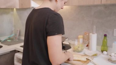 Modern Kitchen 'da Ahşap Kesme Kuruluna İçi Doldurulmuş Kişi Kesme Paketi ve Çeşitli Malzemeler Tezgahta. Pişirme Süreci Konsepti