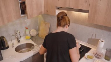 Sarı Vurucu, Mutfak Arkaplanı ve İçindekiler ve Yemek Aletleri ile Bir Cam kâseye Süt Döken Kadın Genel Görünümü