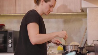 Kadının Yakın Çekimi Kalın Karışımı Paslanmaz Çelik Tencereyle Karıştırılmış Gaz Fırınında Fırça Kullanıyor