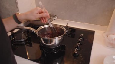 Koyu Meyve Karışımının Yakın Çekimi Silikon Spatula kullanarak bir tencerede karıştırılıyor