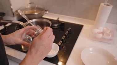 Yakın plan Elleri Cam Kavanozdan şeker çıkartırken bir kaşıkla ocağın üstünde, İçindekilerle Mutfak Tezgahı