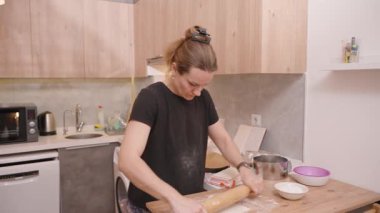 Ahşap Mutfak Tezgahında Yuvarlanan Kadın Yanında Pişirme Aletleri ve Malzemeleriyle, Görevine Odaklandı