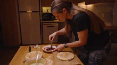 Bir Mutfakta Ev Yapımı Pasta Hazırlarken Bir Kadın Pasta Katmanına Meyve Reçeli Salıyor