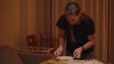Dimly Lit Kitchen 'da Kaşık Kullanarak Pastayı Dikkatlice Dekorasyon Eden Kadın