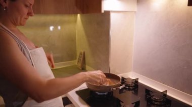 Modern bir Mutfakta Gaz ocağında Biftek Pişirirken Bir Kadın