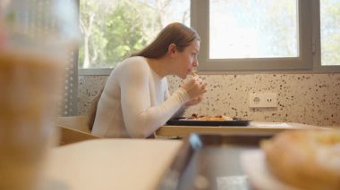 Beyaz Kazaklı Kadın Restoran Masasında Pizza Yerken Önü Bulanık Önü ve Arkaplanda Büyük Pencere Bakıyor