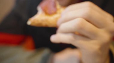 Kırmızı ve Siyah Ceketli Adam Düşünceli bir ifadeyle Uzaklara Bakarken Kısmen Yenmiş Sandviç Tutuyor