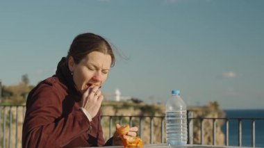 Arka planda Mandalina Yiyen Kadın Su Şişesi ve Manzaralı Okyanus Manzarası