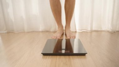 Ahşap zemin üzerinde, Arkaplanda Perdeleri olan Dijital Ölçek Önünde Çıplak Ayaklı Kişi