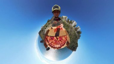 Minik Gezegen Efektli Bir Pizza Kutusu Tutan Adam, Arka planda Eşsiz 360 derecelik Okyanus, Kayalıklar ve Şehir Binaları Görünümü Oluşturdu