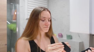 Aynaya Bakan Kadın Uyku Geliştirme için Göz Seviyesi Konseptinden Yatmadan Önce İki Elinle Siyah Ağız Bandını Uyutuyor