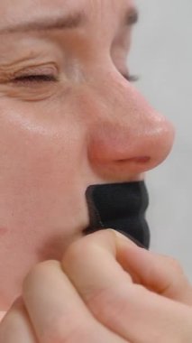 Dikey video. Siyah Ağız Bandı Çeken Kadın, Uyku Sağlığı Konsepti İçin Yakın Bakış Amaçlı Acı Veren İfadeyi Gösteriyor