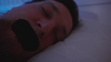 Derin Burun Solunumu Konsepti İçin Loş Mavi Işıkta Yastığa Bantlı Uyuyan Adam 'ın Yakın Çekimi