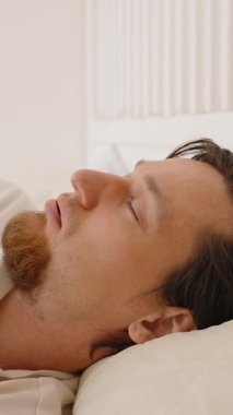 Dikey video. Ağız bandı açılıp yüzerken horlayan ve horlama karşıtı ürün başarısızlığı için yavaş hareket eden adam döner ve devam eder