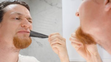 Kırmızı Sakallı Adam Yan Açı 'dan Siyah Ağız Bandını çıkarırken Gıcırdıyor, Uyku Teybi Rahatsızlığı Konsepti