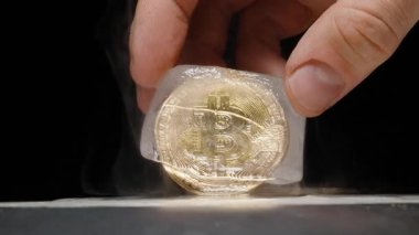 Elle tutulan Bitcoin Isıtılmış Metal bir yüzeyde kısmen erimiş bir buz küpü içinde, yükselen buharla, finansal belirsizliği ve piyasa istikrarsızlığını temsil eden