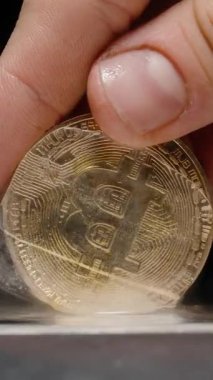 Dikey video. Isıtmalı Metal Yüzeyinde Erimiş Buz Küpü 'nden Bir Bitcoin Sikkenin Çıkarılması, Buhar Yükselişi, Piyasa Kurtarma ve Finansal Geri Dönüşü Sembolize Ediyor