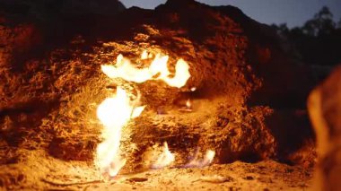 Türkiye 'deki Chimaera' daki Rocky Yarığından Yanan Doğal Alevlerin Yakın Çekimi, Akşamları Engebeli Taş Yüzeyi Aydınlatan Parlak Sarı ve Turuncu Ateş