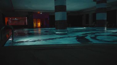 Geniş Açı Bakış Açısı, Lüks Sağlıklı Bakış Alanından Yakaladığı Geniş Destek Sütunları ve Havuz Merdivenleri 'nin yer aldığı Mavi Su Işığı Altında Geniş Kapalı Havuz