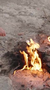Dikey video. Türkiye 'deki Chimaera' da Ebedi Alevlerin Yanında Oturan Kişi, Rocky Zemini 'ndeki Eşsiz Açık Hava Faaliyetleri' nden çıkan Doğal Ateşin Üzerinde Şekerleme Yapıyor.